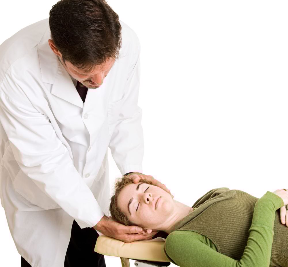 Chiropractor performing a neck adjustment on a patient lying on a treatment table.
