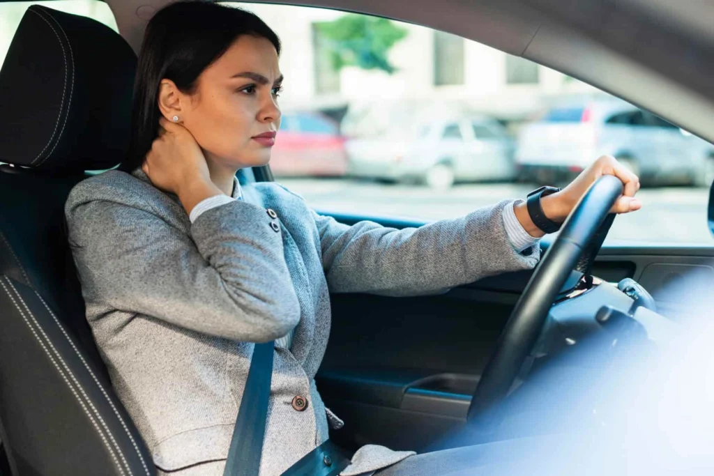 Female business woman holding her neck after an auto accident causing whiplash