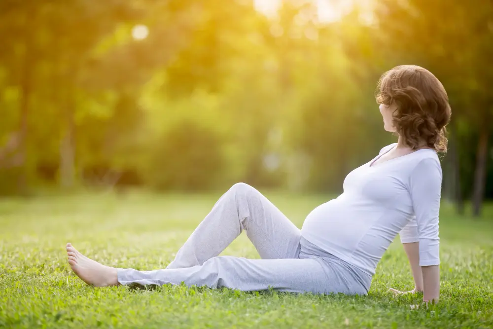 Pregnant woman sitting outdoors with back discomfort