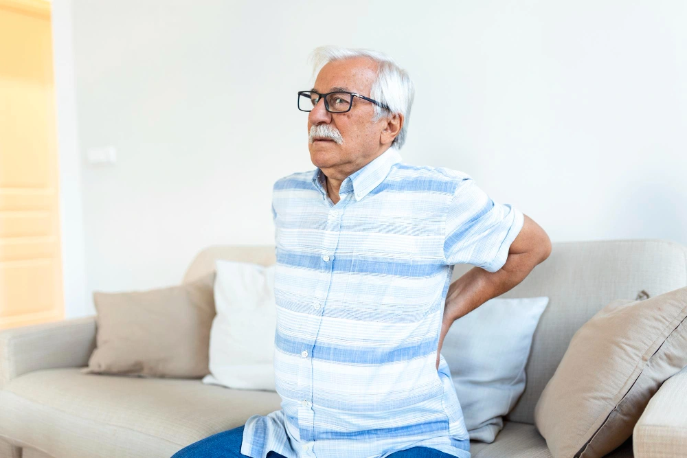 Senior man experiencing herniated disc pain in lower back