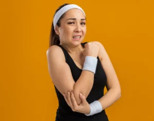 Patient experiencing tennis elbow pain receiving chiropractic treatment
