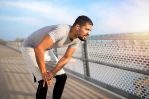 Runner experiencing outer knee pain caused by IT band tightness and strain