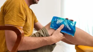 Person applying a heating pad or ice pack to relieve pain