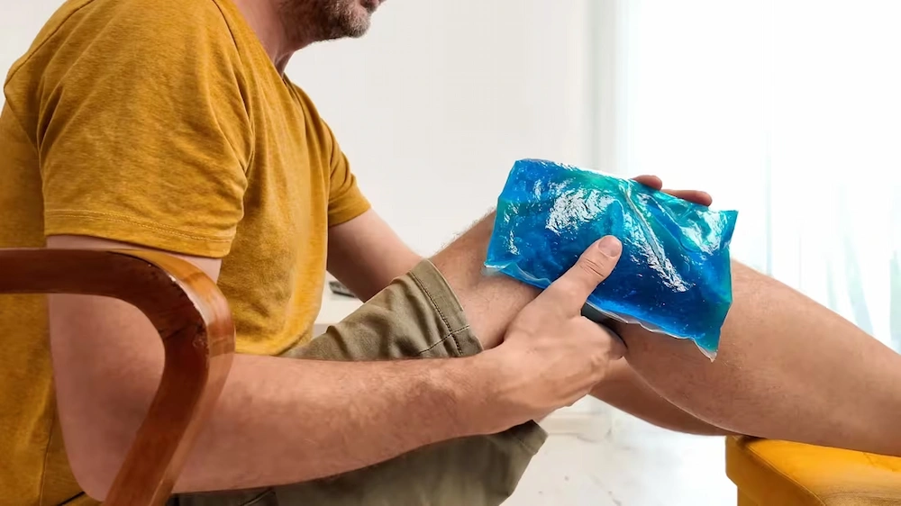 Person applying a heating pad or ice pack to relieve pain